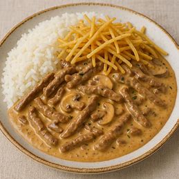 Strogonoff de carne seca cremoso, servido com arroz branco e coberto com batata palha.