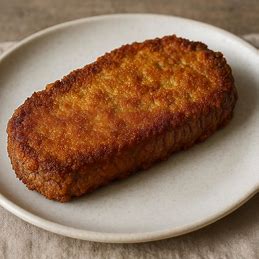 Um bife empanado com uma casquinha dourada e crocante em um prato.