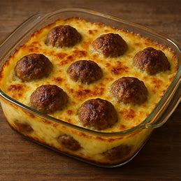 Almôndegas gratinadas com purê de batatas em um refratário de vidro, com uma crosta de queijo gratinado.