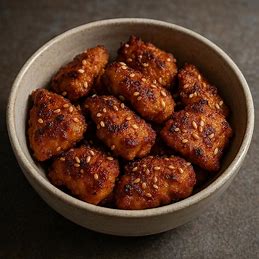 Tigela com iscas de frango douradas, crocantes e polvilhadas com gergelim.