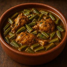 Frango com quiabo em um prato de barro, com um molho escuro e cremoso.