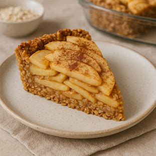 Torta de Maçã e Aveia Fit. Foto de uma fatia de torta de maçã com a massa feita de aveia, com fatias de maçã visíveis e salpicada com canela.