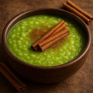 Mingau de milho verde servido em tigela rústica com canela em pau.