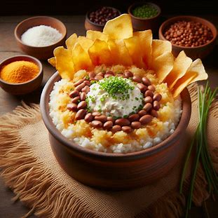 Baião de dois com queijo coalho e chips de mandioca servidos em prato fundo com cebolinha.