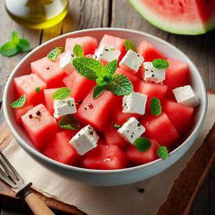 Salada de melancia e queijo feta com hortelã em tigela clara.
