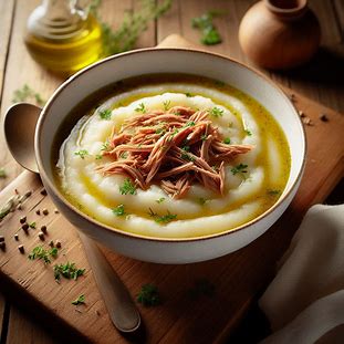 Sopa cremosa de mandioquinha com carne desfiada servida em tigela branca.